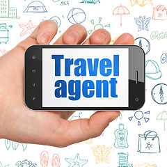 Image showing Tourism concept: Hand Holding Smartphone with Travel Agent on display