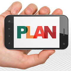 Image showing Business concept: Hand Holding Smartphone with Plan on  display