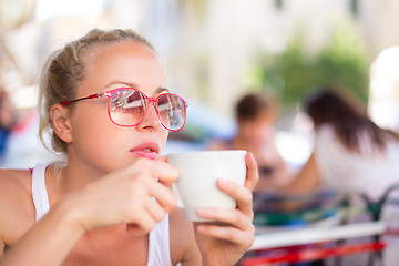 Image showing Woman drinking coffee outdoor on street.