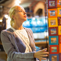 Image showing Casual blond woman shopping for vacation souvenirs.