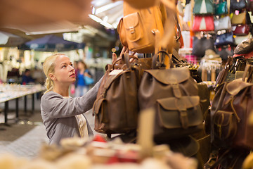 Image showing Casual blond woman shopping for leather bag.