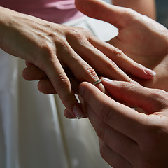 Image showing groom puts ring on the finger of bride