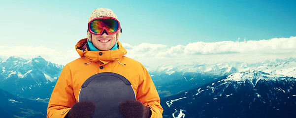 Image showing happy young man in ski goggles over mountains