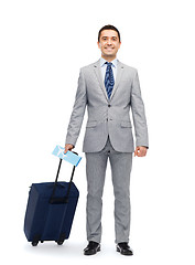 Image showing happy businessman in suit with travel bag