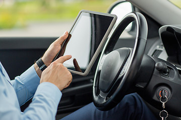 Image showing close up of young man with tablet pc driving car