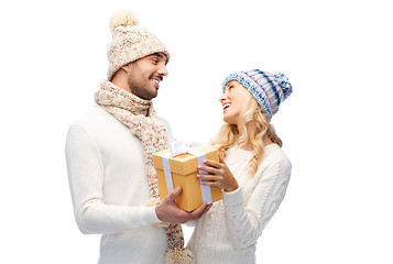 Image showing smiling couple in winter clothes with gift box