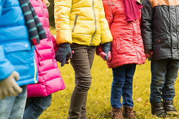 Image showing close up of children holding hands in autumn park