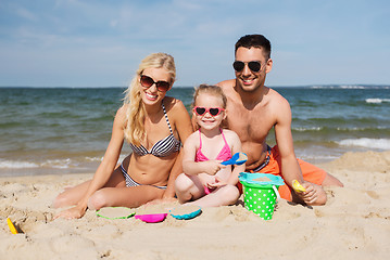 Image showing happy family playing with sand toys on beach