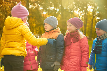 Image showing kids in autumn park counting and choosing leader