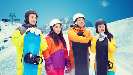 Image showing happy friends with snowboards over mountains