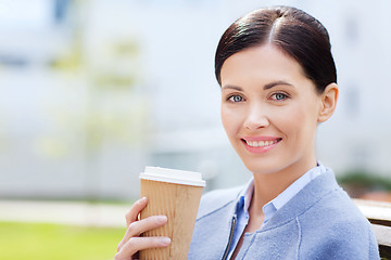 Image showing smiling woman drinking coffee outdoors