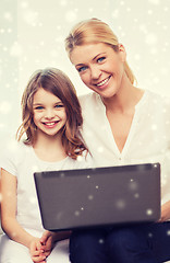 Image showing smiling mother and little girl with laptop at home