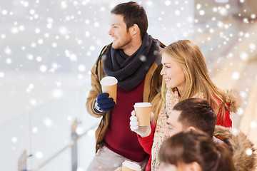 Image showing happy friends with coffee cups on skating rink