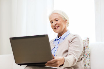 Image showing happy senior woman with laptop at home