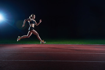 Image showing Athletic woman running on track