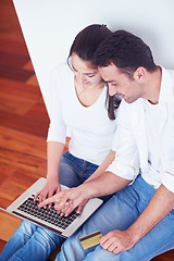 Image showing relaxed young couple working on laptop computer at home