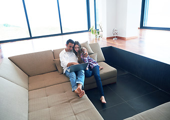 Image showing relaxed young couple working on laptop computer at home