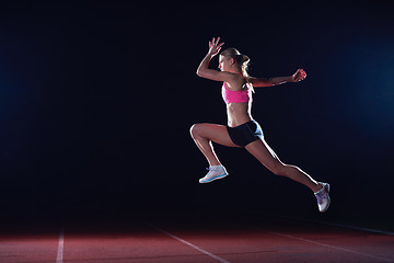 Image showing Athletic woman running on track