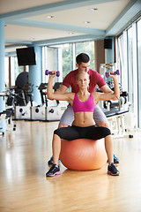 Image showing young sporty woman with trainer exercise weights lifting