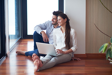 Image showing relaxed young couple working on laptop computer at home