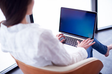 Image showing relaxed young woman at home working on laptop computer