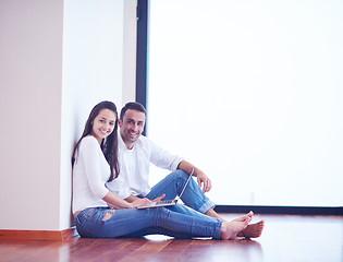 Image showing relaxed young couple working on laptop computer at home