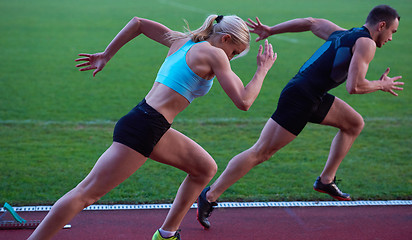 Image showing woman group  running on athletics race track from start