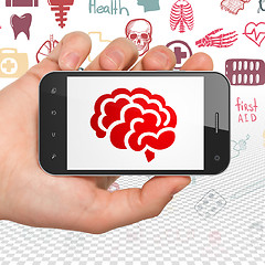 Image showing Health concept: Hand Holding Smartphone with Brain on display