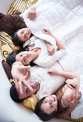 Image showing handsome man in bed with three beautiful woman