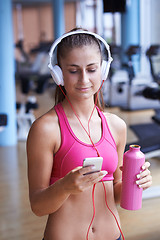 Image showing woman with headphones in fitness gym
