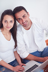 Image showing relaxed young couple working on laptop computer at home