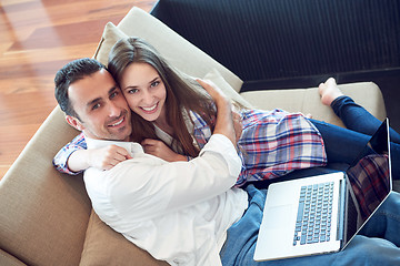 Image showing relaxed young couple working on laptop computer at home