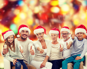 Image showing happy family in santa hats showing thumbs up