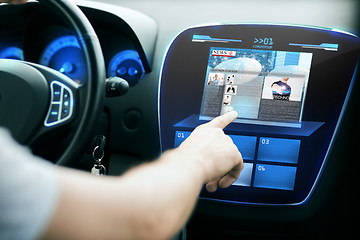 Image showing male hand pointing finger to monitor on car panel