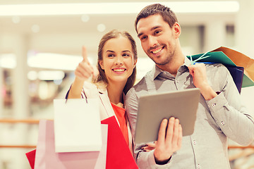 Image showing couple with tablet pc and shopping bags in mall