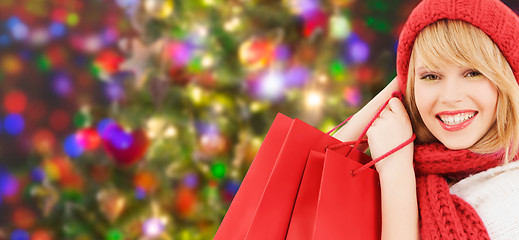 Image showing woman in red hat and scarf with shopping bags