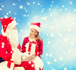 Image showing smiling little girl with santa claus and gifts