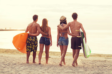 Image showing smiling friends in sunglasses with surfs on beach