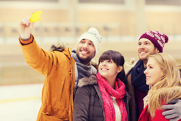 Image showing happy friends taking selfie on skating rink