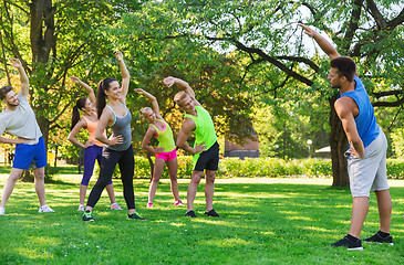 Image showing group of friends or sportsmen exercising outdoors