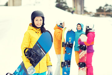 Image showing happy friends in helmets with snowboards