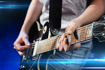 Image showing musician playing electric guitar with mediator