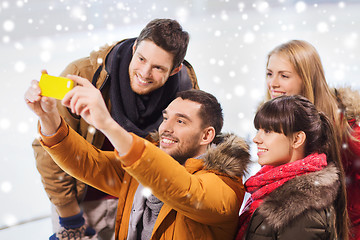 Image showing happy friends with smartphone on skating rink