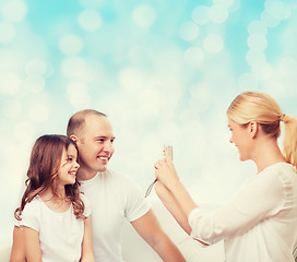 Image showing happy family with camera at home