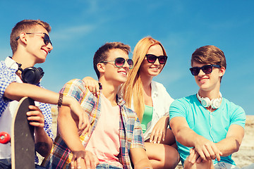 Image showing group of smiling friends sitting on city street