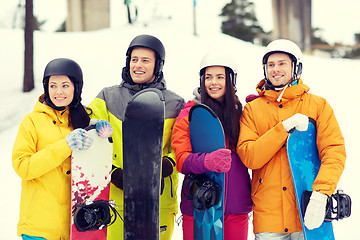 Image showing happy friends in helmets with snowboards