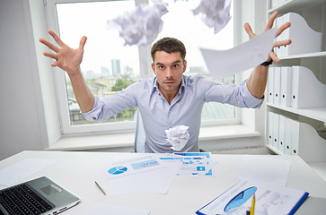 Image showing angry businessman throwing papers in office