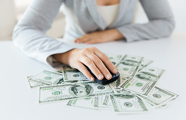 Image showing close up of hand with computer mouse on money