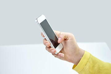 Image showing close up of female hand with smartphone at home