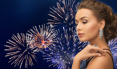 Image showing beautiful woman with diamond earring over firework